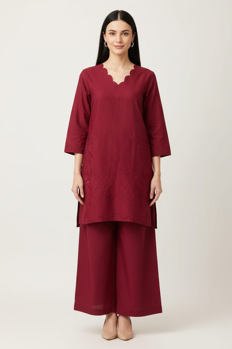 Woman wearing a maroon outfit with a plain background