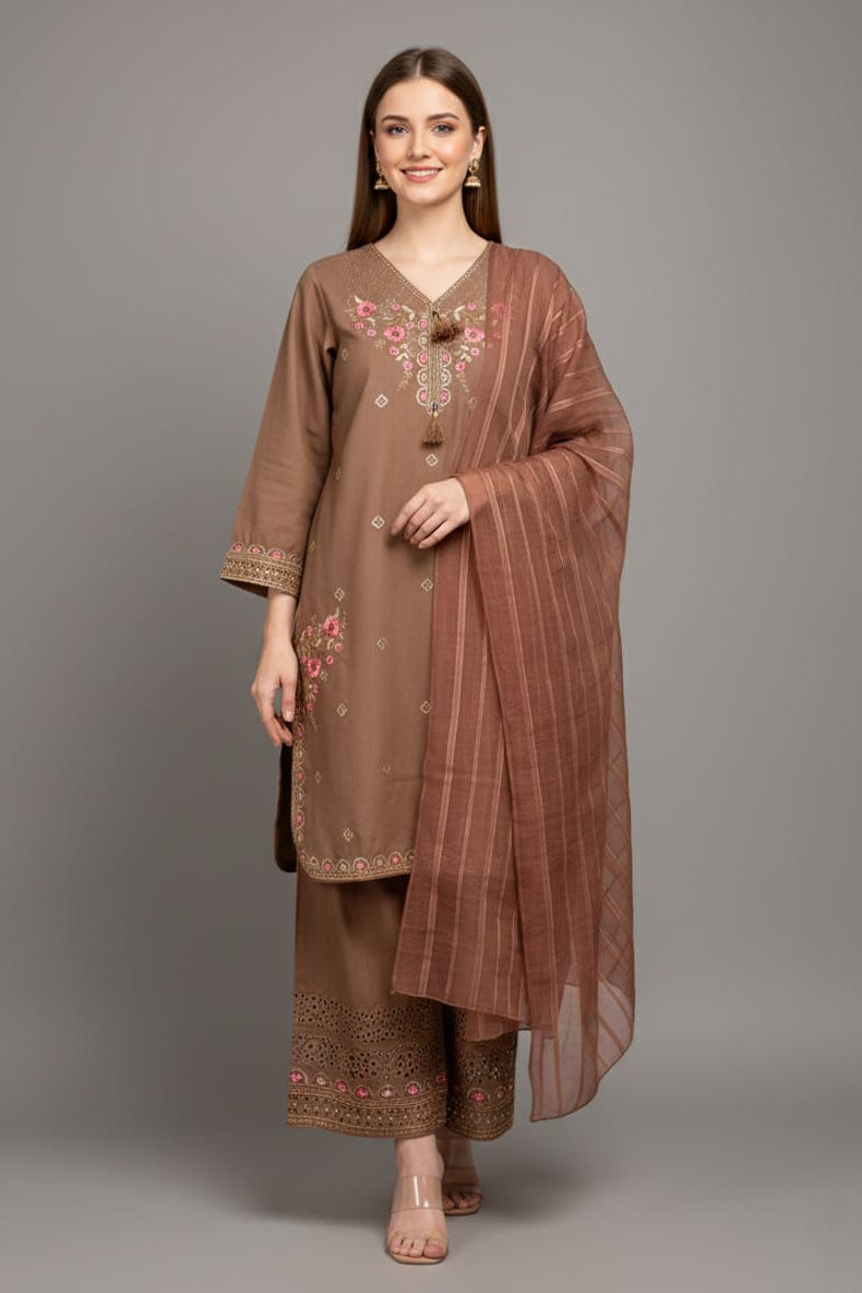 Woman wearing a brown embroidered outfit with a matching dupatta on a gray background
