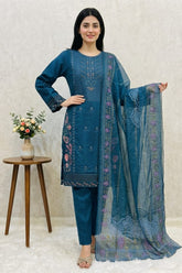 Woman in a blue embroidered outfit holding a matching dupatta against a neutral background