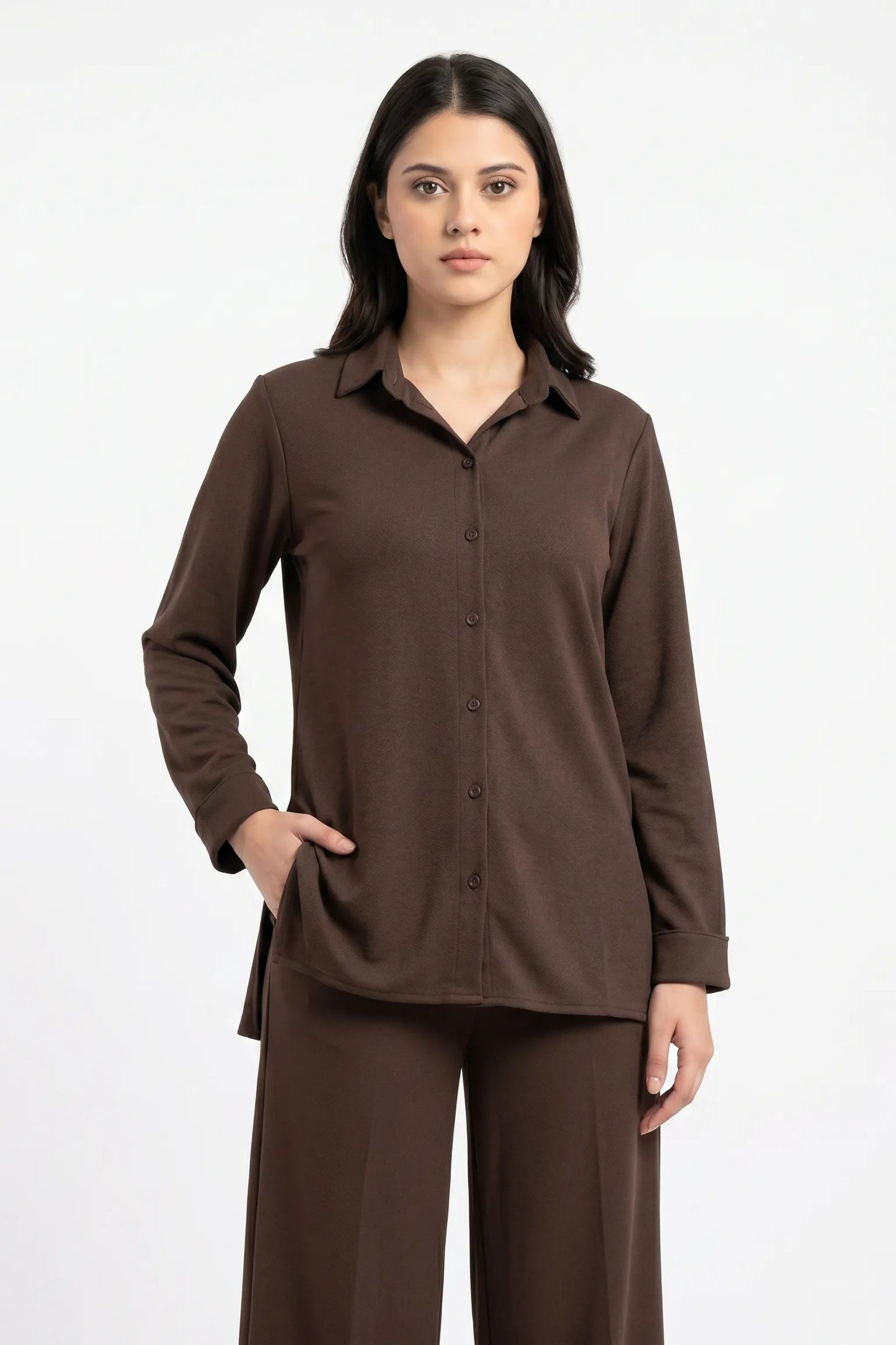 Woman wearing a brown shirt and pants on a white background