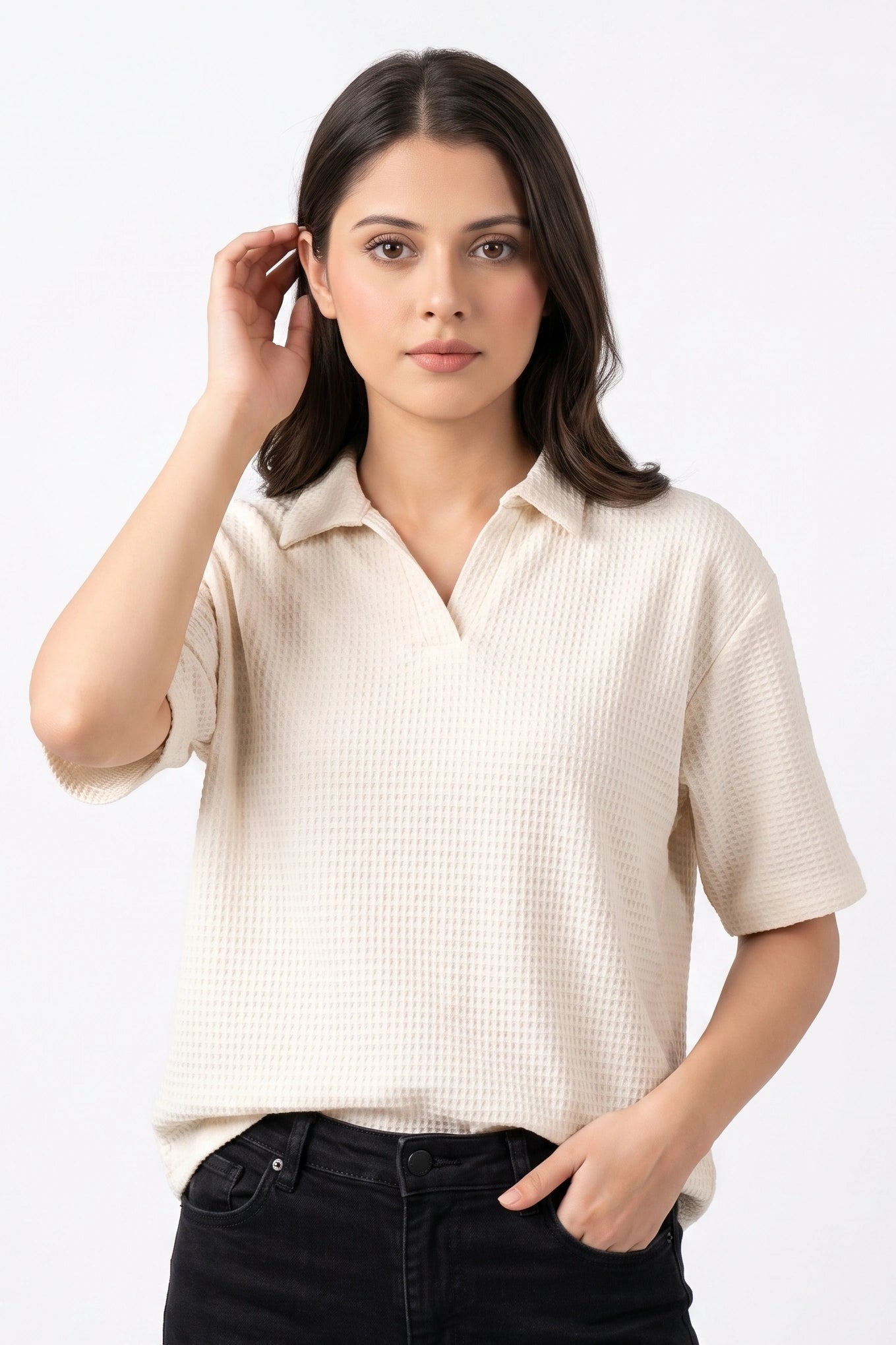 Front view of a model wearing an off-white waffle knit open collar shirt paired with black jeans.