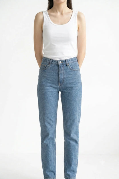 Front view of white premium women's cotton tank top tucked into blue jeans