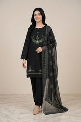 Woman wearing a black embroidered outfit with a sheer dupatta on a beige background