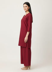 Woman wearing a maroon outfit with a plain background