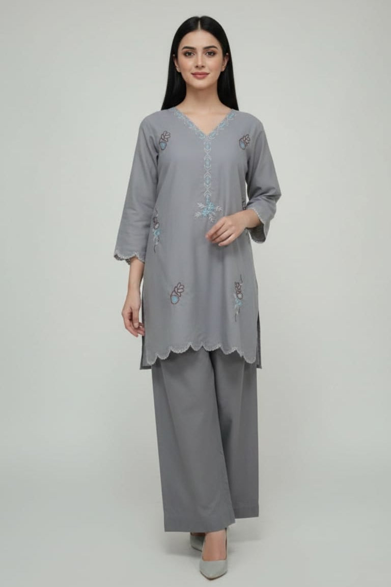 Woman wearing a gray embroidered outfit on a white background