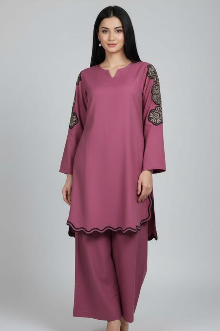 Woman wearing a magenta pink outfit with intricate designs on a plain background