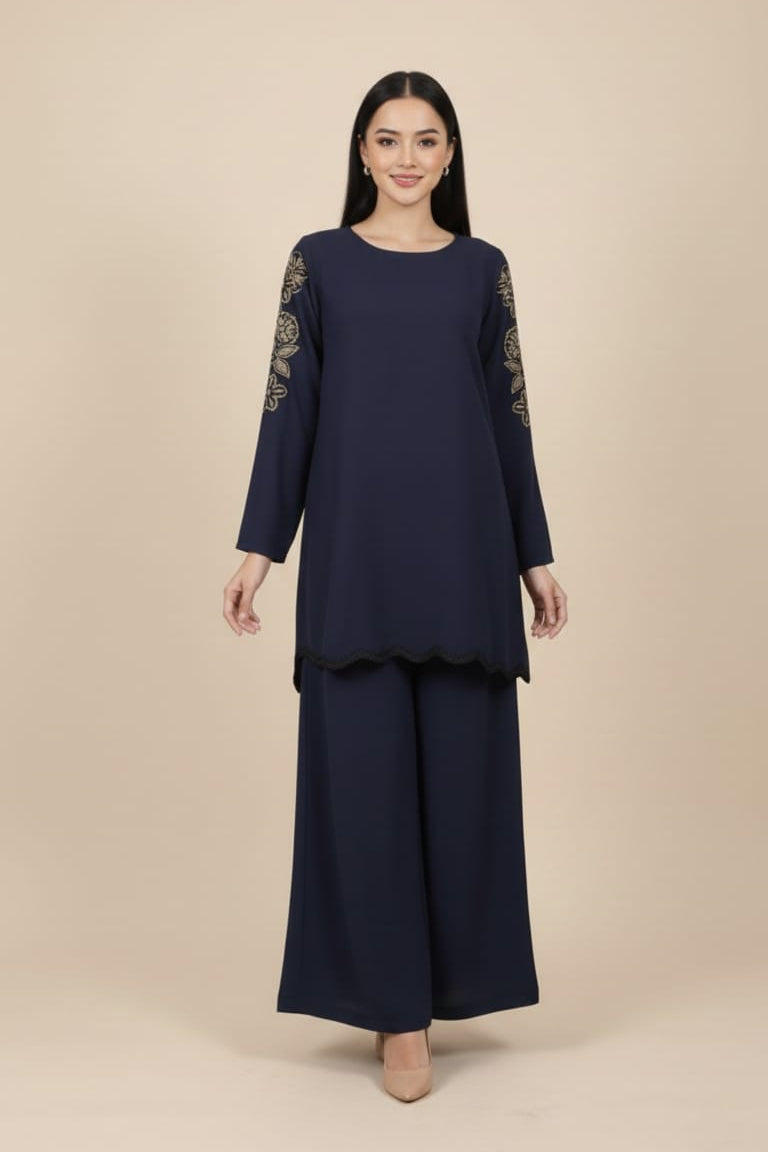 Woman wearing a navy blue outfit with Embroidered sleeves on a beige background