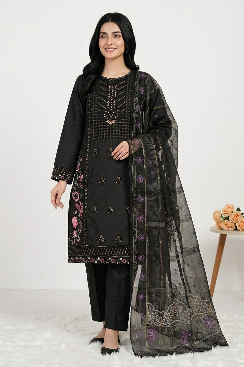 Woman wearing a black embroidered outfit with a sheer dupatta on a white background