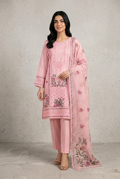 Woman wearing a pink embroidered traditional outfit with a plain background