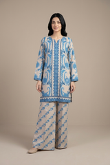 Woman wearing a blue and beige patterned outfit on a beige background