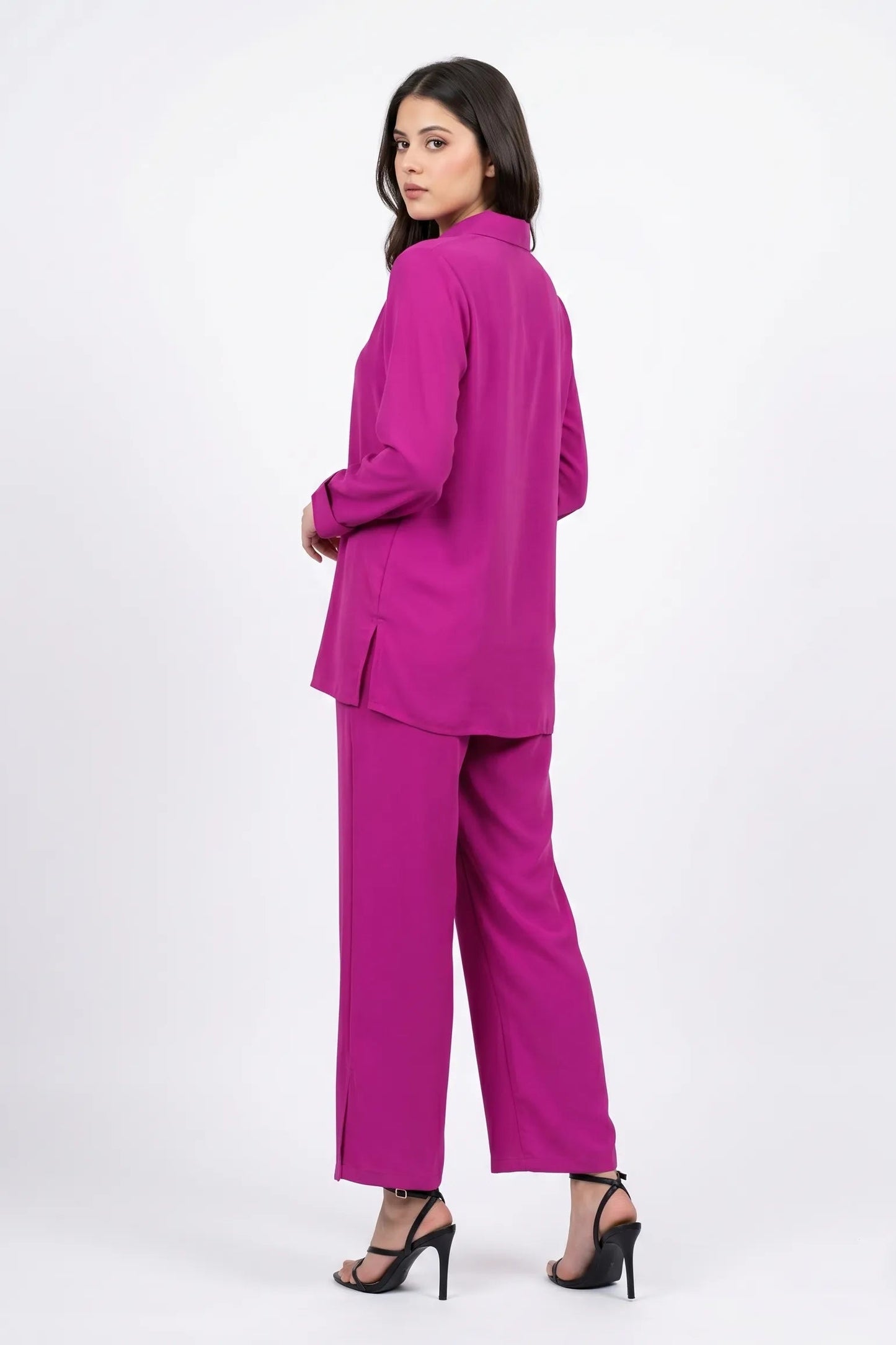 Woman wearing a bright pink suit on a white background