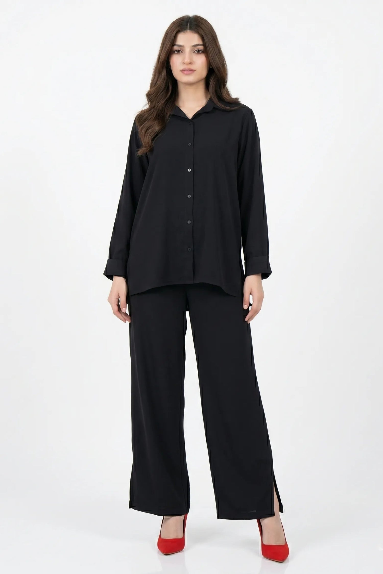 Woman wearing a black outfit with wide-leg pants on a white background