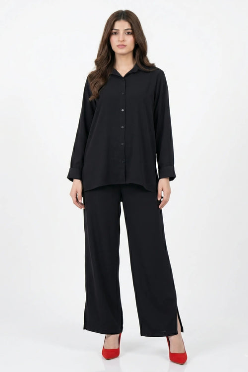 Woman wearing a black outfit with wide-leg pants on a white background