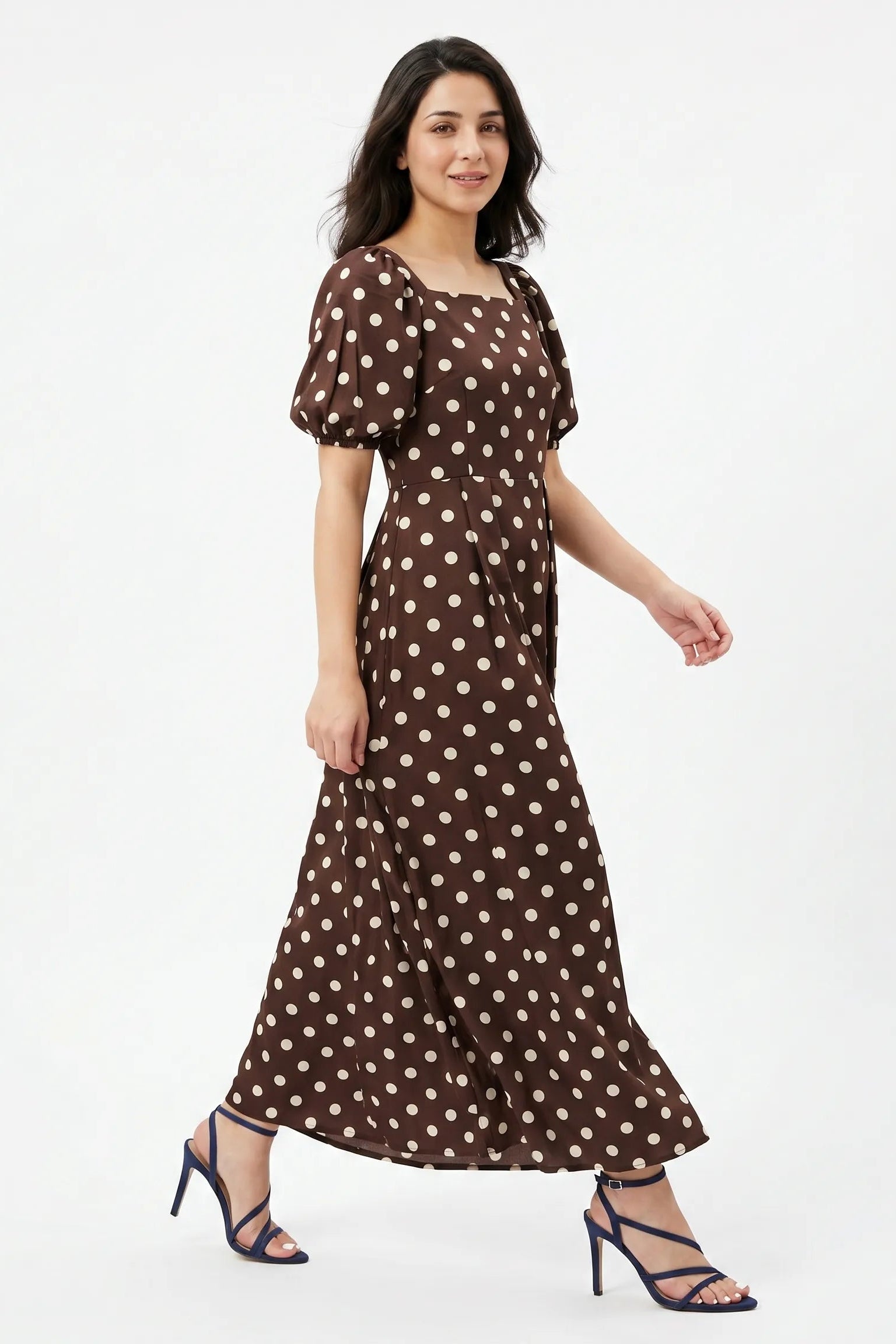 Woman wearing a brown polka dot dress on a white background