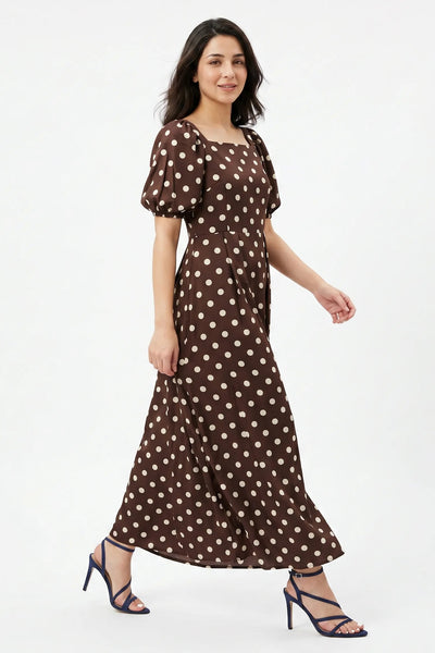 Woman wearing a brown polka dot dress on a white background