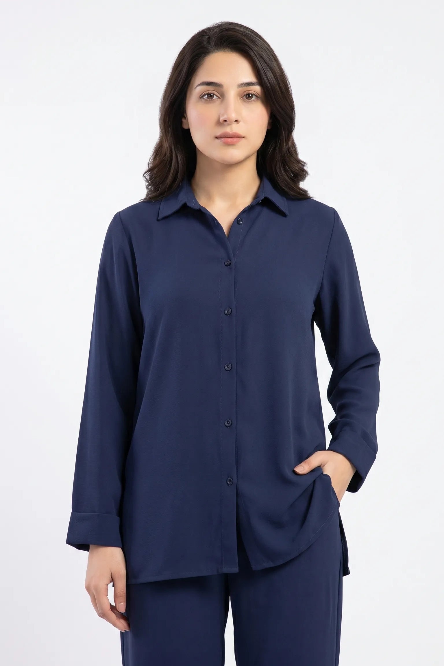 Woman wearing a navy blue shirt and pants on a white background