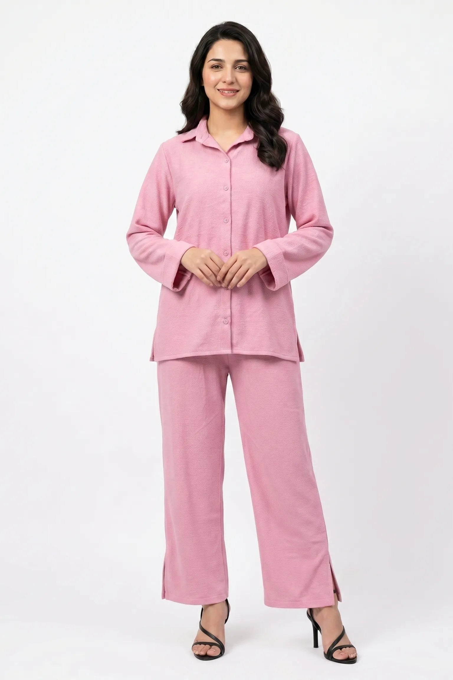 Woman wearing a pink pajama set on a white background