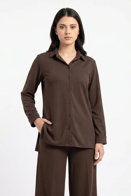Woman wearing a brown shirt and pants on a white background