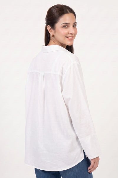A woman wearing a white long-sleeve linen shirt and blue jeans, photographed from the back against a plain white studio background.