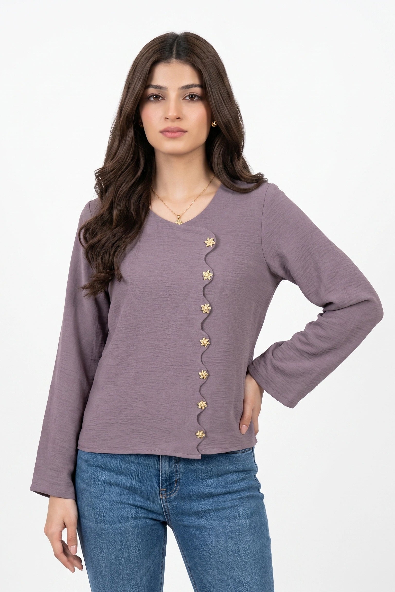 A woman modeling a dusty purple long-sleeve top with decorative gold star-shaped buttons down the front, paired with blue jeans, against a plain white background.